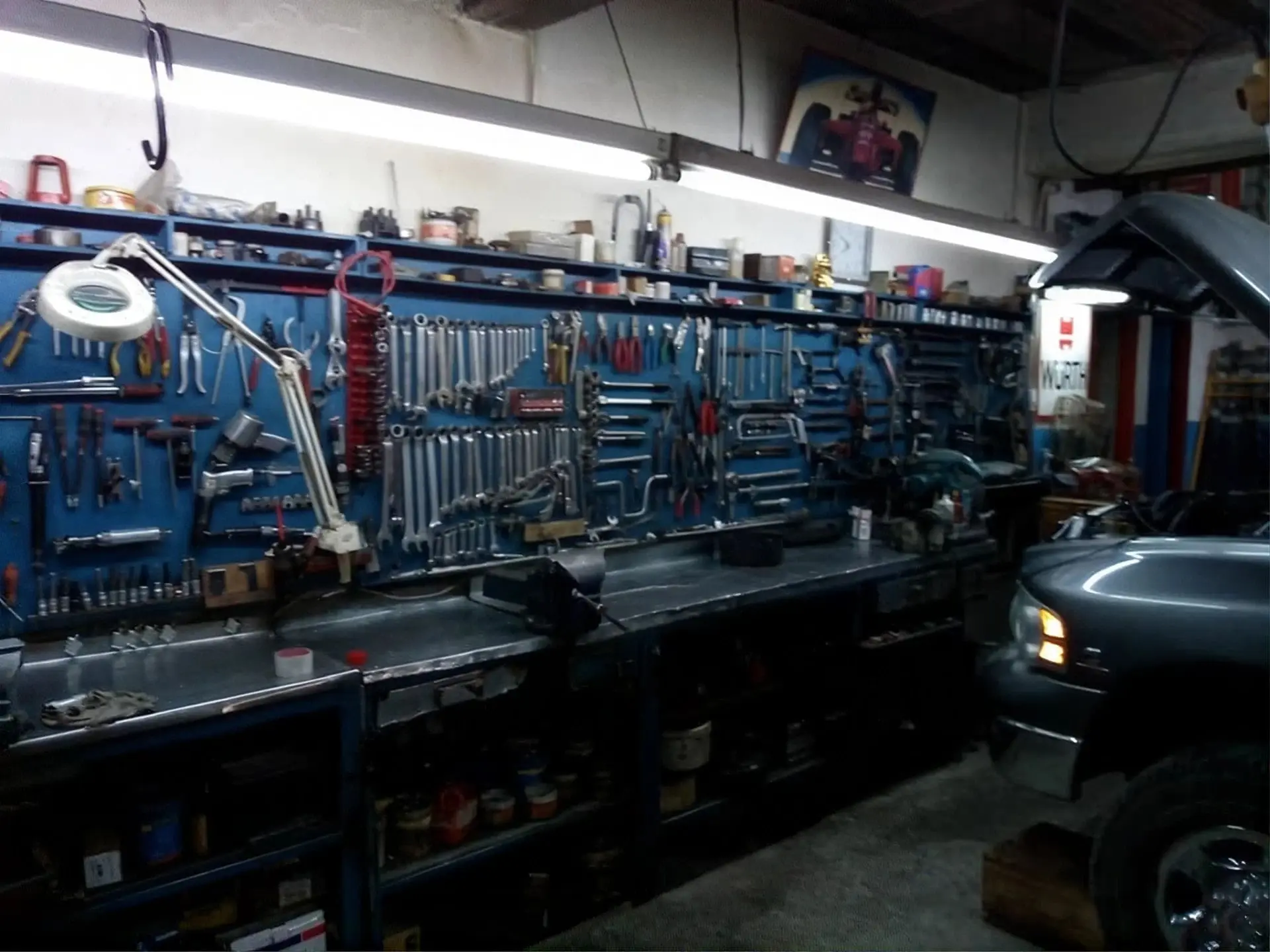 Panel de herramientas y mesa de trabajo del taller, con una camioneta en servicio