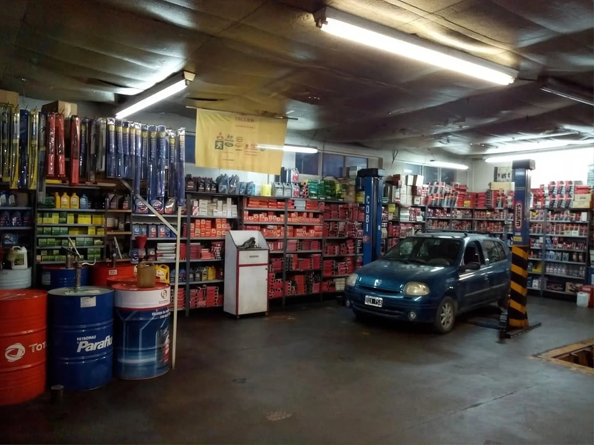Sector de lubricantes y repuestos, con un auto sobre el elevador